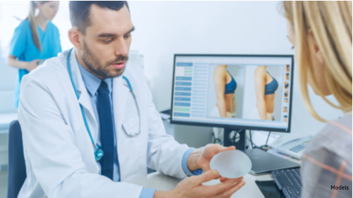 A woman discussing with her doctor the different types of implants she can choose for her breast augmentation.