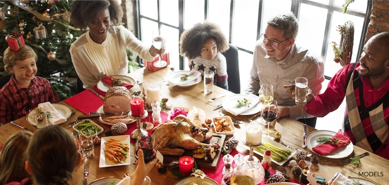 Family sitting around the table on Thanksgiving, enjoying a meal