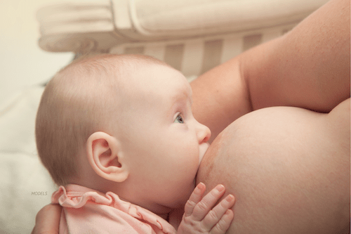 Young baby breastfeeding on mother's breast