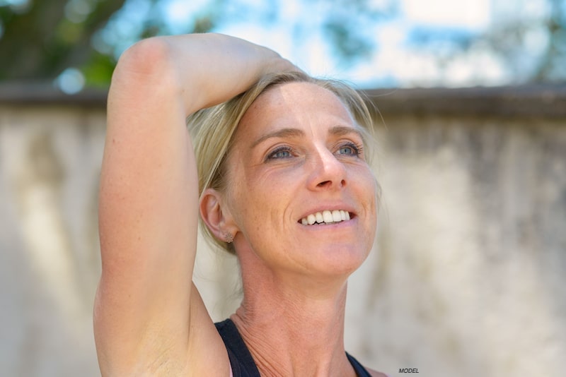 Woman lifting her arm above her head. 