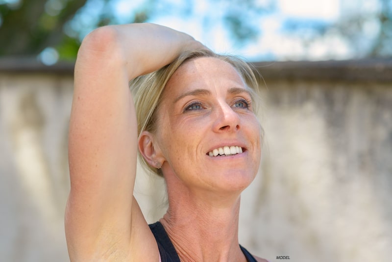 Woman lifting her arm above her head. 