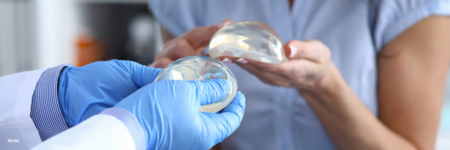 A woman and her surgeon compare breast implants